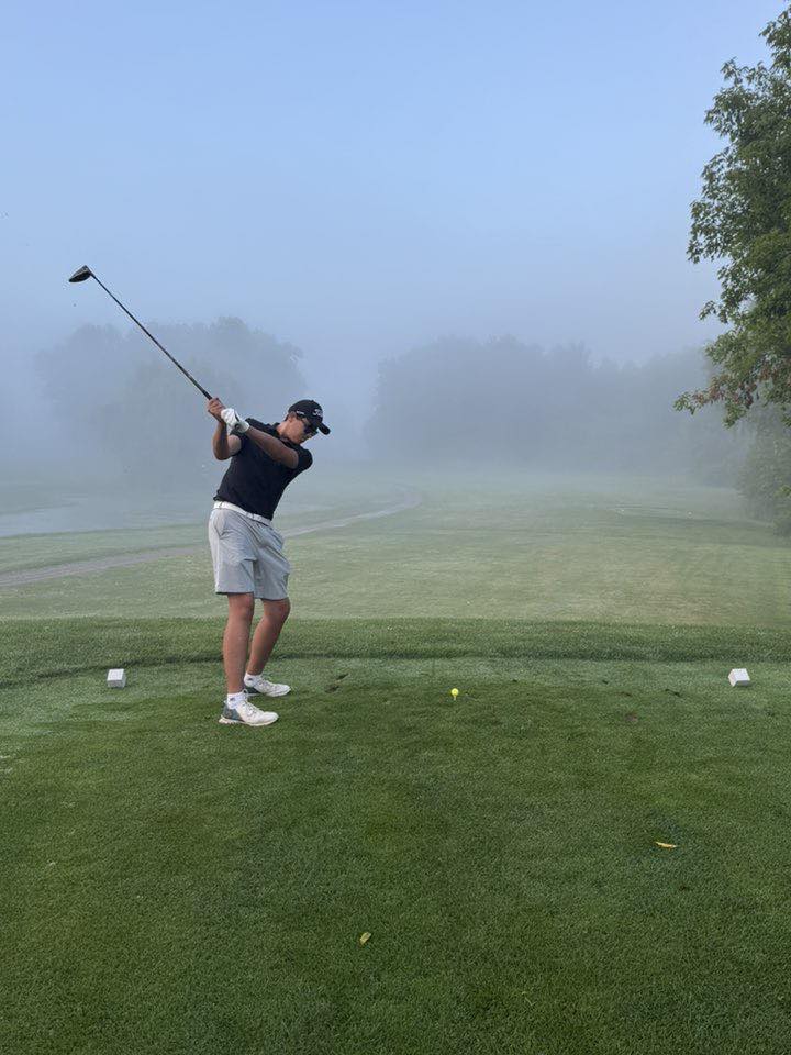 Golfer taking a swing on golf course